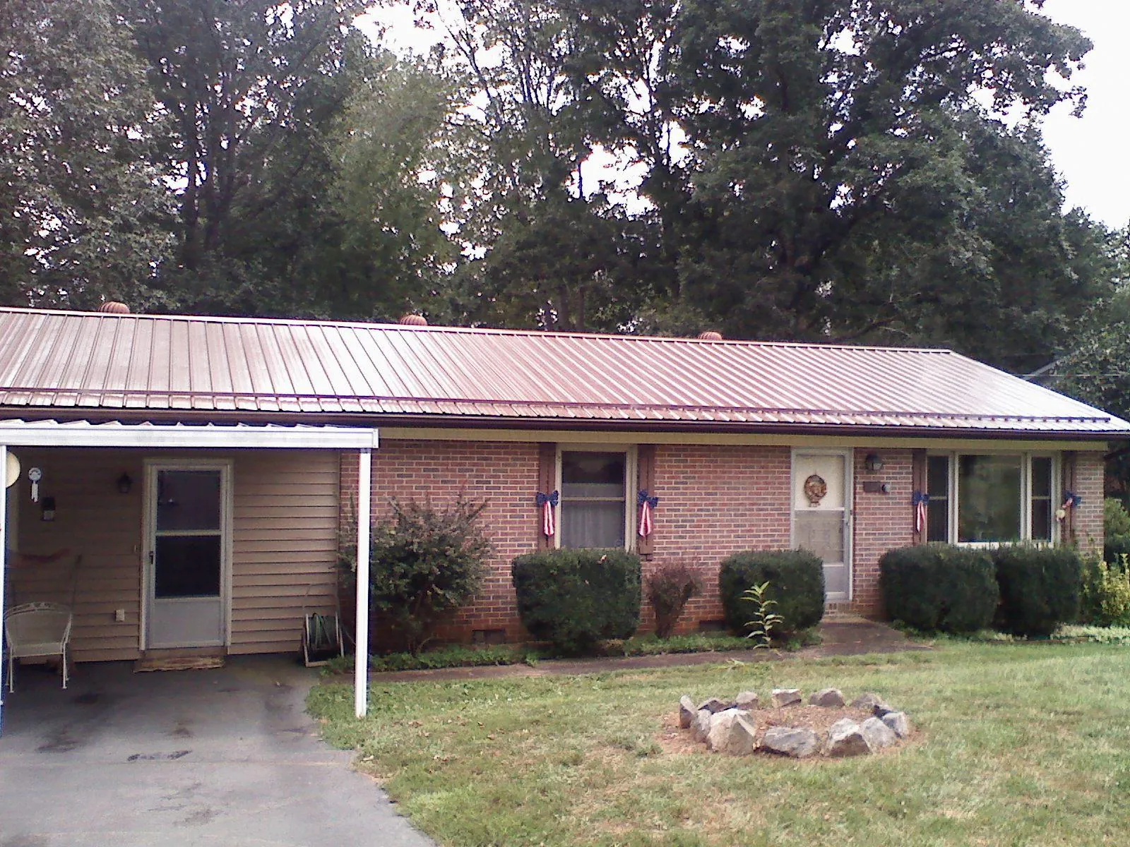 Bronze metal roof and carport on a brick ranch home — Roof Repair work by our crew in Allentown